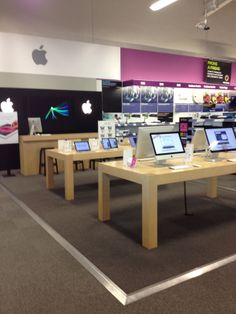 an apple store with multiple computers on tables in front of the computer screen and display