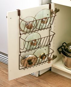 pots and pans are stored in a rack on the shelf next to an oven