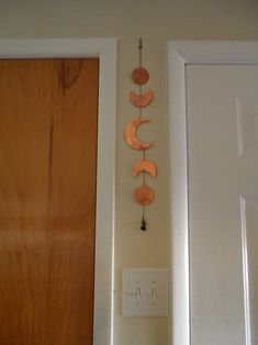 a wooden door with a clock hanging on it's side next to a wall