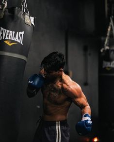 a man standing next to a punching bag