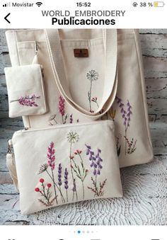 two purses with embroidered flowers on them, one is white and the other is pink