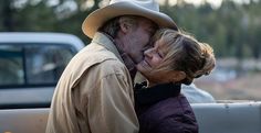 a man and woman kissing in the back of a pick up truck