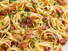 pasta with bacon and parsley in a white bowl