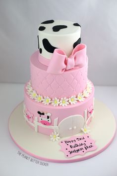 a pink cake with white and black polka dots on the top is decorated with a cow