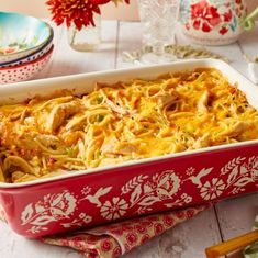 a casserole dish with chicken and noodles in it on a table next to other dishes