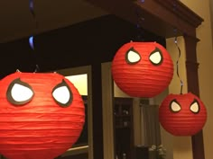 three red paper lanterns with eyes hanging from the ceiling