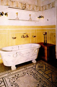 an old fashioned bathtub in a bathroom with yellow walls and floor tiles on the wall