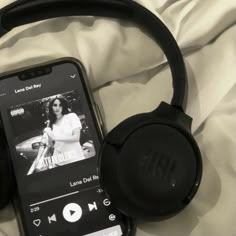 an mp3 player and headphones laying on top of a white sheet with the cover pulled down