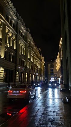 cars are driving down the street at night