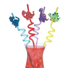 four colorful plastic straws in a glass vase with liquid and candy sticks sticking out of it