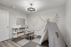 a child's room with a teepee tent and desk