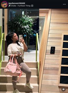 a woman taking a selfie while sitting on some stairs with a pink handbag