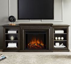 an entertainment center with a fireplace and flat screen tv