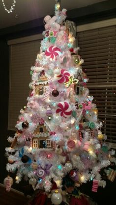 a white christmas tree decorated with candy canes and candies