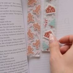 a person is reading a book with gingerbread stickers on it and an open book in the background