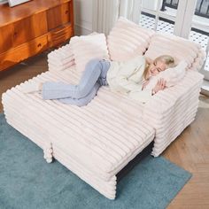 a woman laying on top of a couch in a living room