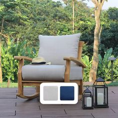 a rocking chair sitting on top of a wooden deck next to a lamp and lantern