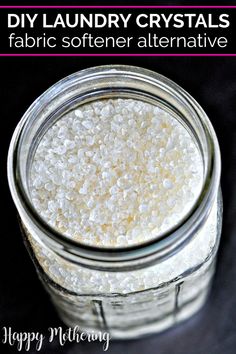 a glass jar filled with white stuff on top of a black table next to the words diy laundry crystals fabric softener alternative