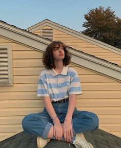 a young woman sitting on top of a roof