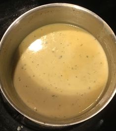 a silver pot filled with liquid on top of a stove