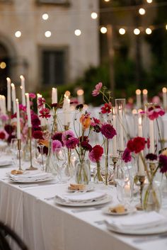 a long table is set with flowers and candles for an elegant dinner or reception party