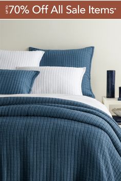 a bed with blue and white bedspreads on it