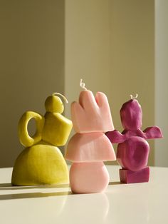 three small figurines sitting on top of a white table next to each other