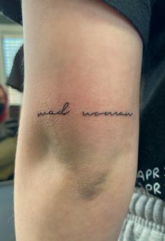 a person with a small tattoo on their arm that says, mad woman in cursive writing