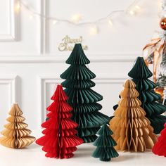 small christmas trees are lined up on the table