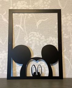 a mickey mouse head cut out in the shape of a frame on top of a table