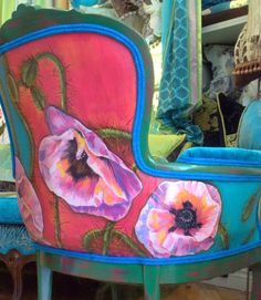 an artisticly painted chair with flowers on it's back and side view mirror in the background