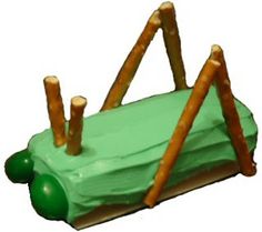 a cake shaped like a green car with sticks sticking out of it's roof