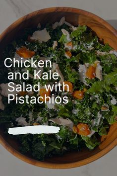 chicken and kale salad with pistachios in a wooden bowl on a table