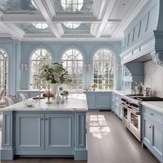 a large kitchen with blue cabinets and white counter tops, along with an island in the middle