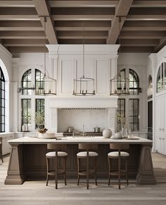 a large kitchen with an island in the middle and four stools at the end