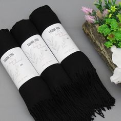 three black towels are sitting next to some flowers