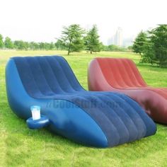 two inflatable chairs sitting on top of a lush green field