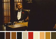 a man in a tuxedo sitting at a desk with a color swatch