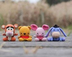 four crocheted stuffed animals lined up on the ground