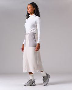 The Double Face Fleece Skirt is a thick, lightweight fleece bottom. The skirt is made from Polartec 200 Series Fleece, with stretchable polyester panels on the face and lining. The skirt features an A-line design, button and zipper closure at the front, stretchable sections through the waist and hip, two zippered pockets at the waist, and a zippered back pocket. Fleece Skirt, Double Face, Line Design, Skirt, Zipper, Black, Design