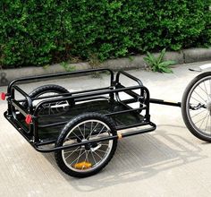 a bike with a trailer attached to the front wheel and two wheels on the back