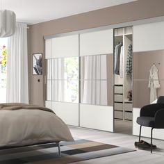 a bedroom scene with focus on the bed and closet doors that have been opened to let in light