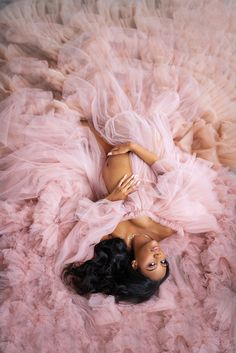 a mannequin laying on top of a pink fluffy bed covered in tulle