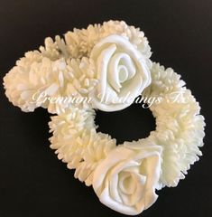 three white roses are on top of each other in the shape of an oar