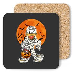 a coaster with an image of a person dressed as a ghost holding a pumpkin and bats