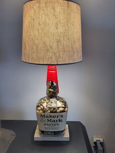 a lamp that is sitting on top of a table next to a bottle with rocks in it