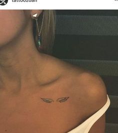 a woman's chest with an angel tattoo on her left shoulder and two wings