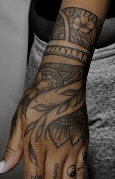 a person with tattoos on their arm and hand