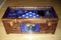 a wooden box with an american flag and other items in it on top of a hard wood floor