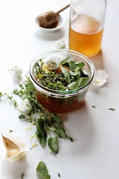 a glass jar filled with flowers and herbs